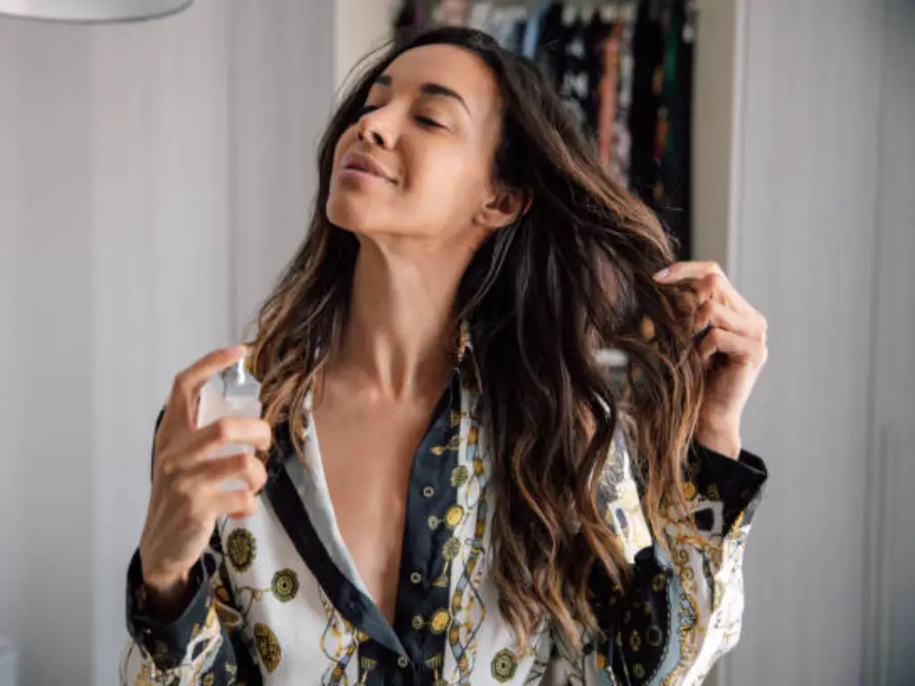 a lady spraying perfume