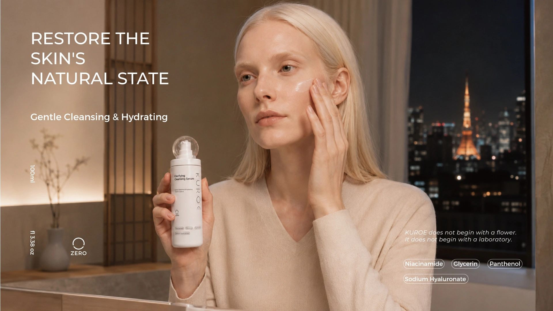 Model applying KUROE Clarifying Cleansing Serum in a Tokyo apartment at night with the city skyline through the window