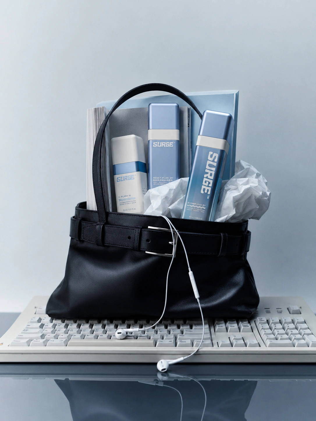 SURGE™ set peeking from a black leather bag resting on a vintage keyboard